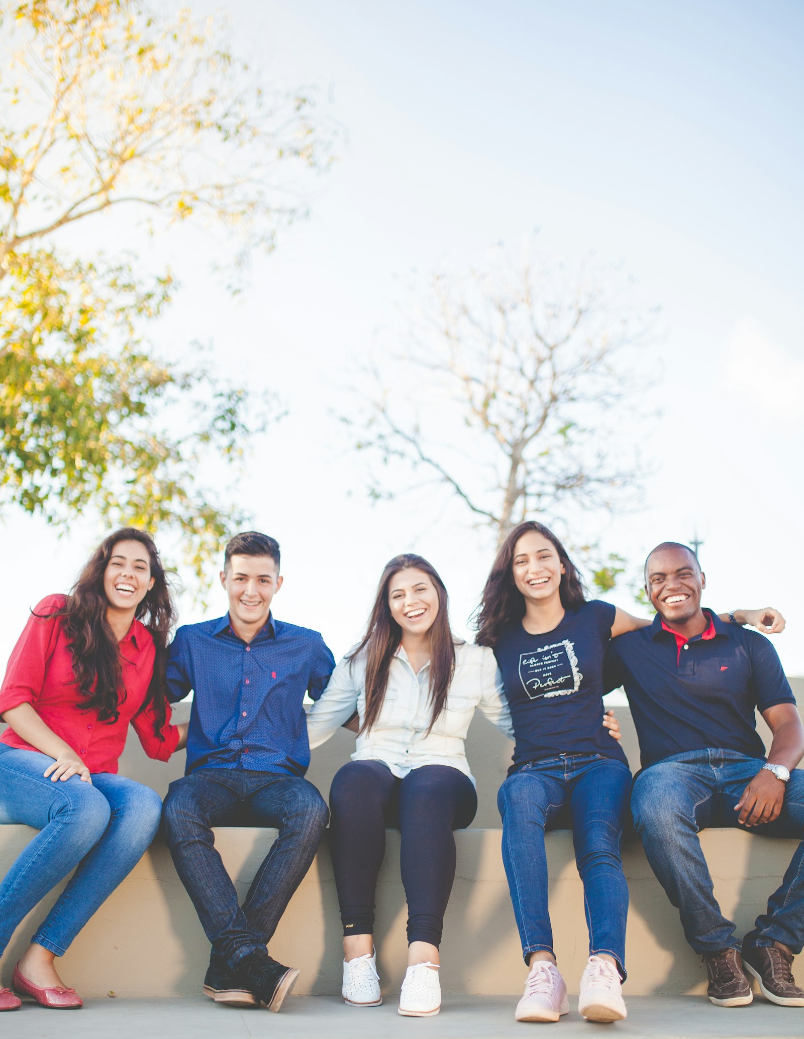 A diverse group of university friends sitting together outdoors